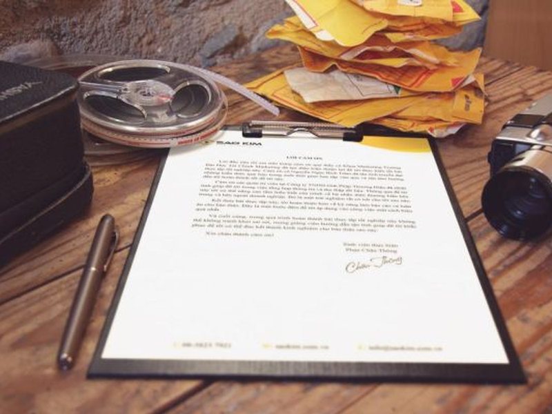 Documento assinado sobre uma mesa de madeira, com caneta ao lado
